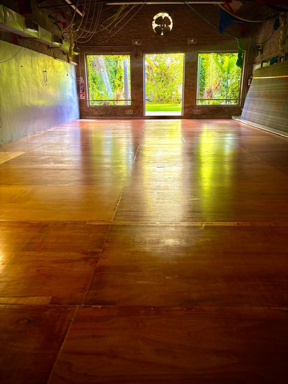 Sala vacía con piso de madera y vista al jardín